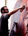 Fintan Magee painting a collab mural with Numskull in Newtown