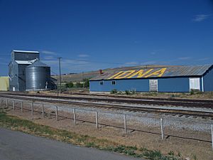 A grain elevator near the train tracks.