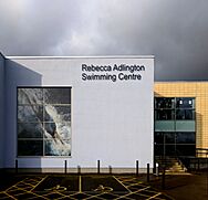 Modern slab sided building in sun and shade against a grey sky