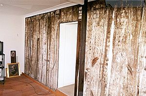 1412 - Timber Slab Cottage - Interior wall of existing cottage showing original split timber vertical slabs. (5049609b2)