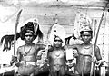 COLLECTIE TROPENMUSEUM Drie jonge Molukers van de Tanimbar-eilanden met hoofdtooien speren en klewangs TMnr 10005682