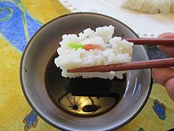 Showing how to dip a piece of sushi into a bowl of soy sauce.jpg
