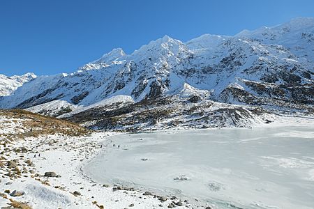 View down to shore of frozen Hooker Glacier Lake in winter