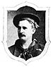 Head of a white man with mustache wearing a sailor suit with a scarf tied around the neck and a flat cap. Around the portrait is a shield-shaped frame.