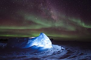 Aurora australis dancing over an LED illuminated igloo