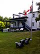 Two Muskoka chairs and a Canada flag overlooking Hawthorne Cottage