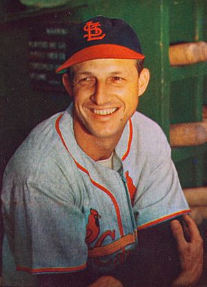 A playing-age Stan Musial in his baseball uniform, looking to the left and smiling