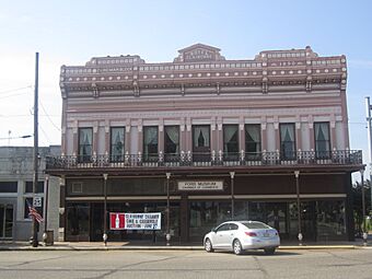 Two-story brick commercial buildings with an elaborate faced including a cast-iron gallery.