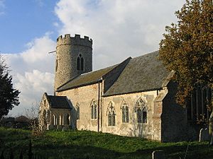 A stone church seen from the southeast, showing the chancel and nave with Decorated windows, the south porch carried on open arches, and the round, battlemented tower