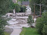 Okotoks - June 20, 2013 - Flood waters rush past library foot bridge