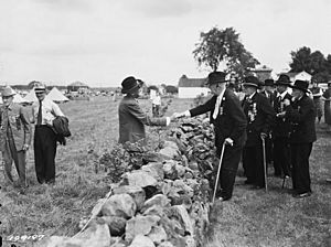 Photograph of Union and Confederate Veterans Shaking Hands Across the Stone Wall at the 1938 "Blue and Gray Reunion" at Gettysburg - NARA - 4529731 (cropped)