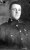 Head and shoulders of square-jawed man in circa 1920 formal U.S. Marine uniform.