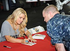 US Navy 101001-N-3793B-071 Jessica Simpson autographs a photo for a Sailor during a USO and Navy Entertainment sponsored visit aboard USS Harry S