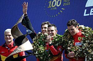 The winning Ferrari 499P Hybrid drivers, Antonio Giovinazzi, Alessandro Pier Guidi & James Calado on the podium at the 2023 Le Mans (53468132601)