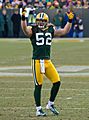 A picture of Clay Matthews in uniform on the field with his hands in the area, presumably to pump up the home team crowd.