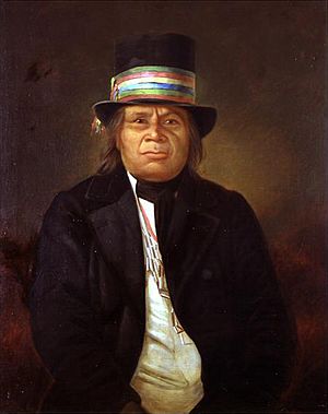 Portrait of Chief Oshkosh posting in a top hat and coat