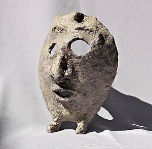 Paper mache mask with feet with grey background