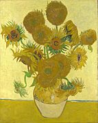 A ceramic vase with sunflowers on a yellow surface against a bright yellow background.