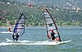 Windsurfers on the river with a forested hillside in the background