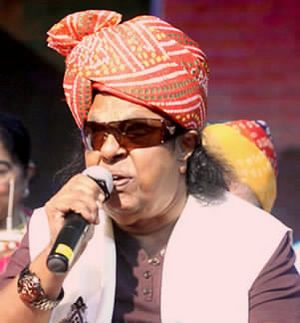 Hindi man with a microphone on a stage in 2015