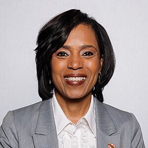 Official Senate headshot of Alsobrooks smiling on a grey background, wearing a white shirt and dark grey jacket with a Maryland flag lapel pin.