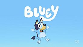 An animated image of an anthropomorphic Blue Heeler puppy, jumping in the air with her arms thrown out beside her, smiling. The dog is coloured blue and displayed in front of a blue background. The word "Bluey" is above her head in white lettering.
