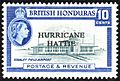 A rectangular postage stamp, denoting that the stamp is of the British Honduras and costs ten cents. In the center there is a picture of the terminal to Stanley Field Airport, with the words 'HURRICANE HATTIE' printed over it. At the bottom of the stamp reads 'Postage & Revenue'.