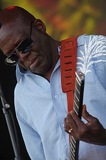 Portrait of a black male playing a guitar