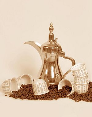 A dallah a traditional Arabic coffee pot with cups and coffee beans