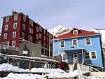 Large three-storied houses on a slope painted in light blue.