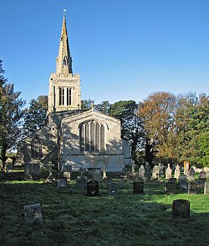 A stone church seen from the east, with a Perpendicular east window, and the end of the south aisle, the tower and spire visible beyond