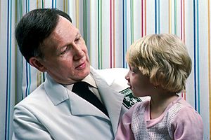 Young girl sits on doctor's lap