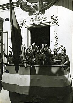 Fotografía del Jefe Territorial de la Falange Española Sancho Dávila y Fernández de Celis en Sevilla saludando desde el balcón de la casa cuartel