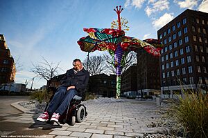Yinka Shonibare CBE RA in front of the Hibiscus Rising sculpture. LEEDS 2023.jpg