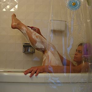 Mujer afeitando sus piernas