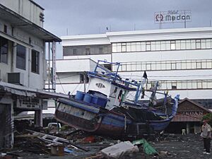 US Navy 050101-O-XXXXB-054 Boats washed ashore near local businesses in down town Aceh, Sumatra following a massive Tsunami that struck the area on the 26th of December 2004