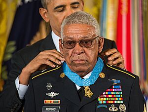 President Barack Obama (background) presents a Medal of Honor to former U.S. Army Sgt. 1st Class Melvin Morris during a ceremony March 18, 2014, in the White House, Washington, D.C. - 140318-A-KH856-005 (cropped).jpg