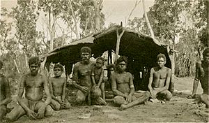 Aboriginal boys and men in front of a bush shelter - NTL PH0731-0022