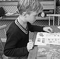 Jongen bezig met een postzegelverzameling, Bestanddeelnr 252-8770