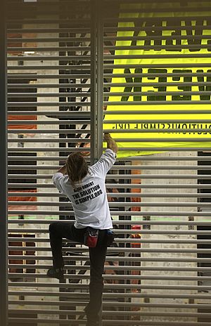 Alain Robert ascend of New York Times Building - 01 - Alain Robert hangs banner