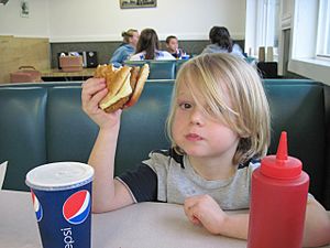 Kid eating veggie burger cc flickr user kellyhogaboom