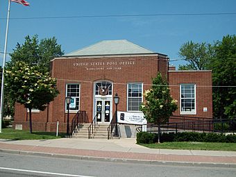 A brick building with two small wings and a peaked roof. "United States Post Office" is spelled out on its front in large letters with "Middleport, New York" below in smaller ones.