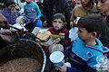 Displaced Palestinians receive food from charitable Tekiya during Ramadan in Deir el-Balah, Gaza Strip