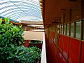 Interior photograph of the Marin County Civic Center. The skylit, two-story atrium has plantings, few sharp corners, and lots of reds and pinks.