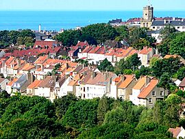 A general view from the Brecquerecque Quarter:The modern lighthouse, the medieval bell tower and the English Channel