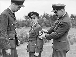 Three American pilots of No. 71 (Eagle) Squadron RAF, Pilot Officers A Mamedoff, V C 'Shorty' Keough and G Tobin, show off their new squadron badge at Church Fenton, Yorkshire, October 1940. CH1442.jpg