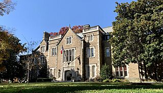 Photograph of a large brick house and the front lawn