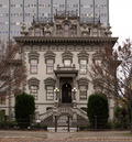 Photograph of the Leland Stanford House, an impressive Victorian with a modern office tower rising behind.