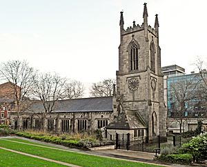 A substantial stone church seen from the north-west.  The tower has crocketted pinnacles, and the north wall of the body of the church has a series of large rectangular windows