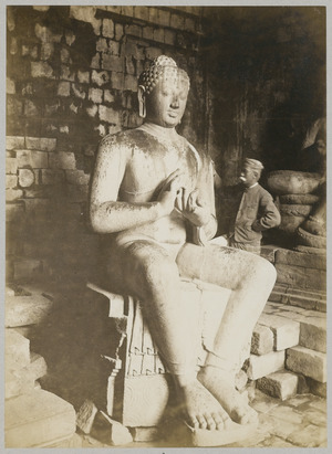 KITLV 12217 - Kassian Céphas - The photographer K. Céphas at the Buddha sculpture in Tjandi Mendoet - 1890